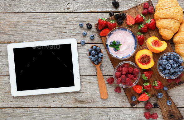 Morning meals and smartphone on rustic wooden table - Stock Photo - Images
