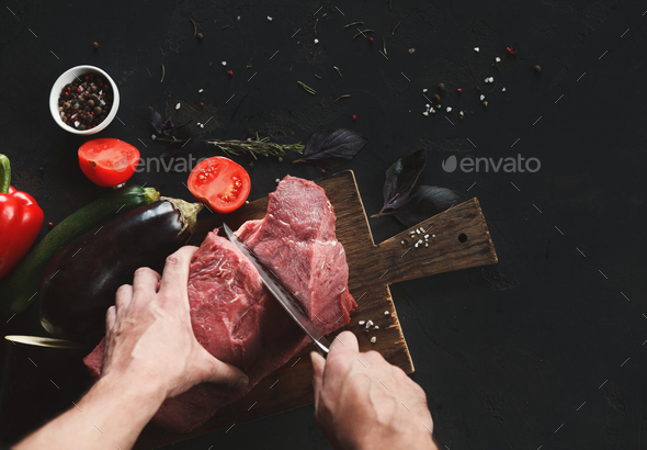 Chef cutting filet mignon on wooden board at restaurant kitchen - Stock Photo - Images