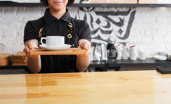 Portrait of young barista at coffee shop counter - Stock Photo - Images