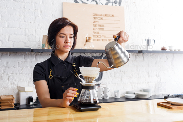 Portrait of young barista at coffee shop counter - Stock Photo - Images
