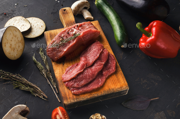 Raw beef filet mignon steaks on wooden board - Stock Photo - Images