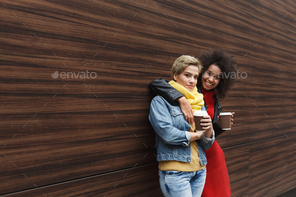 Happy girls with take away coffee outdoors - Stock Photo - Images