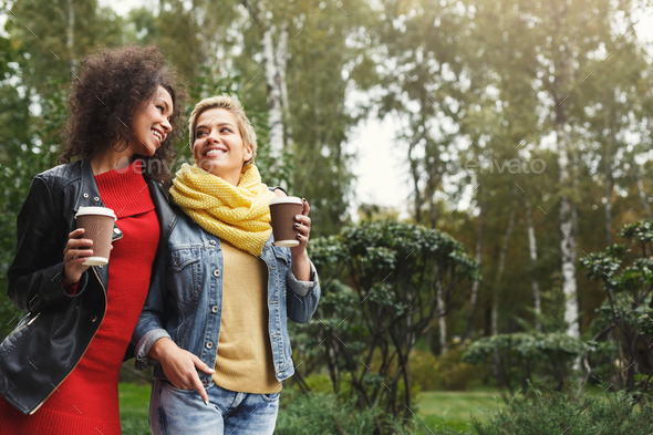 Happy girls with take away coffee outdoors - Stock Photo - Images