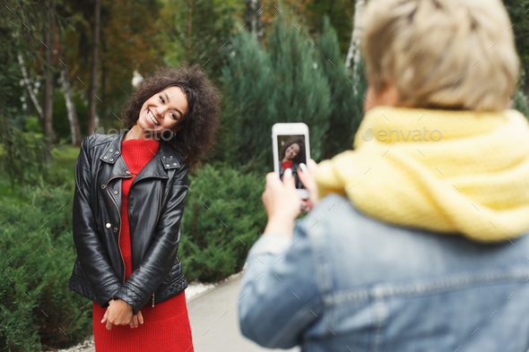 Happy girls with smartphone outdoors in the park - Stock Photo - Images