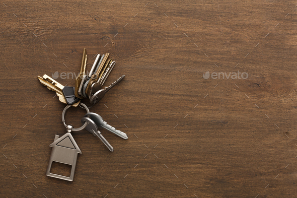 Bunch of keys with house shaped keychain on white wood - Stock Photo - Images