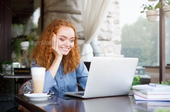 Young redhead female freelancer outdoors working with laptop - Stock Photo - Images
