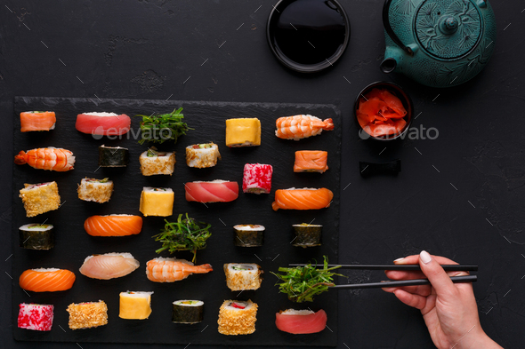 Set of sushi maki and rolls on black background - Stock Photo - Images