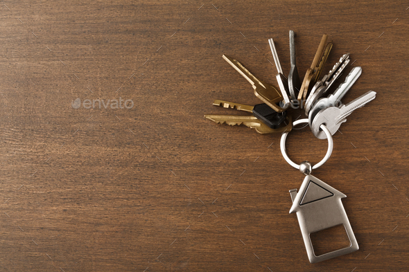Bunch of keys with house shaped keychain on white wood - Stock Photo - Images