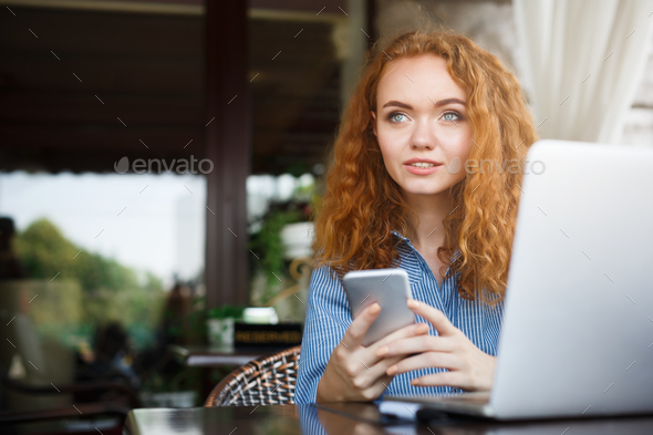 Young redhead girl texting message during lunch - Stock Photo - Images