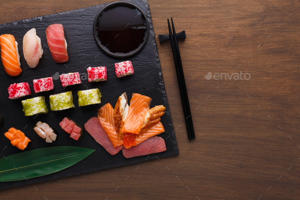 Set of sushi maki and rolls on black rustic wood, top view - Stock Photo - Images