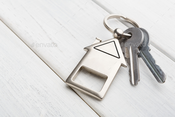 Bunch of keys with house shaped keychain on white wood - Stock Photo - Images