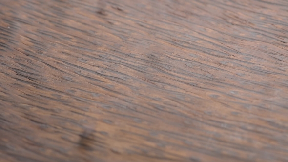 Pouring Red Rice in a Dark Wooden Plate