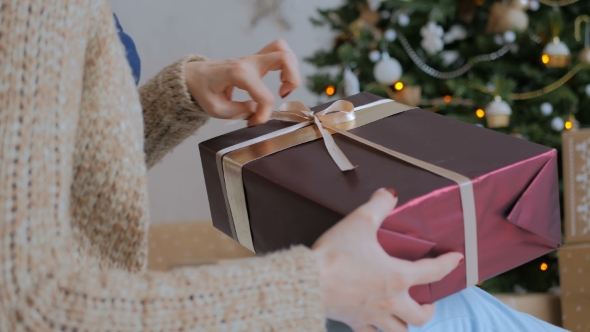 Woman Wraps Ribbon on Christmas Gift Box