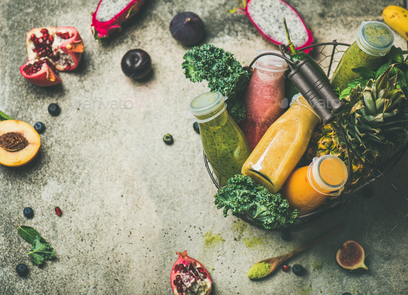 Colorful smoothies in bottles with fruits in basket, copy space - Stock Photo - Images