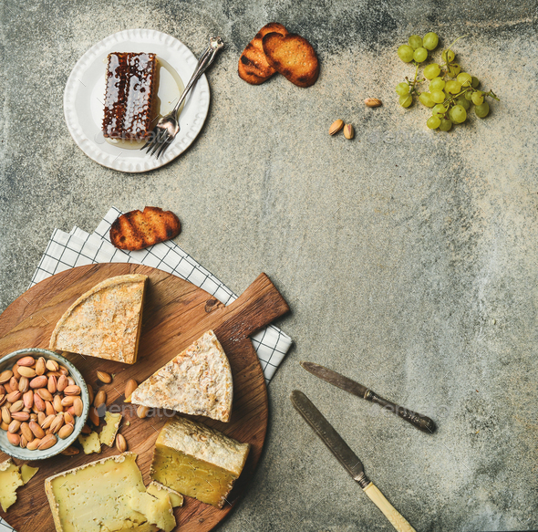 Flat-lay of platter with cheese assortment and snacks, copy space - Stock Photo - Images