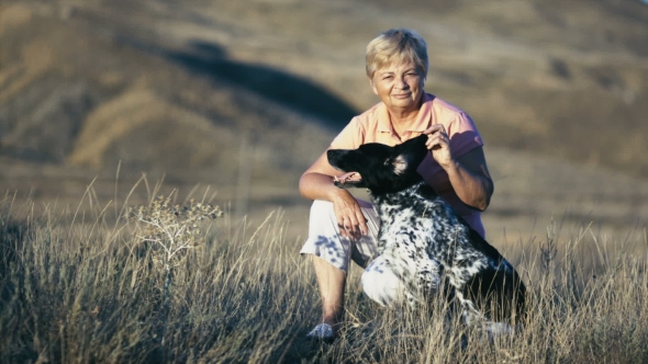 An Elderly Beautiful Woman Stroking a Hunting Dog