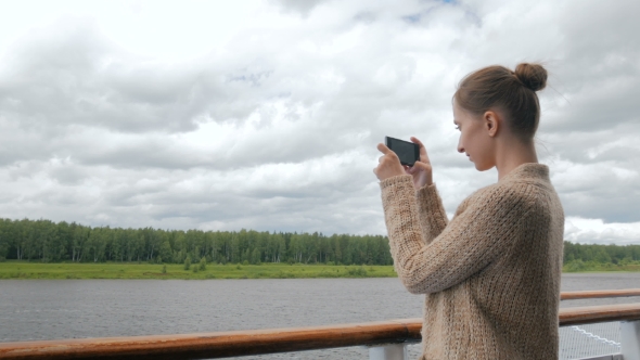 Woman Taking Photo of Landscape with Smartphone on Deck of Cruise Ship