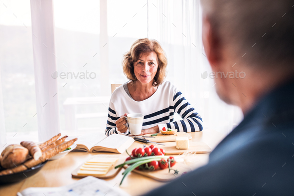 Senior couple eating breakfast at home. Stock Photo by halfpoint | PhotoDune