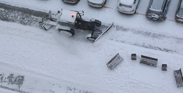 Tractor is Cleaning Sidewalk in Winter