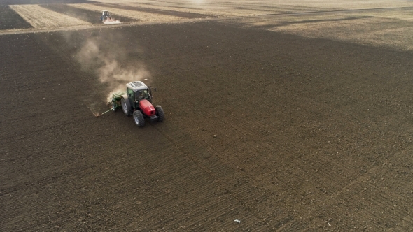 Red Tractor Mounted Seed Drill Plants the Seeds in the Soil in the Experimental Field. Aerial View alt
