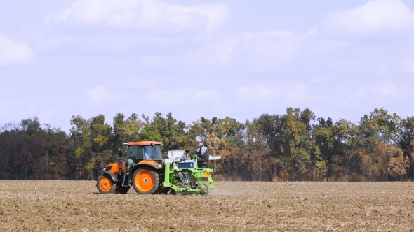Red Tractor Mounted Seed Drill Plants the Seeds in the Soil in the Experimental Field alt