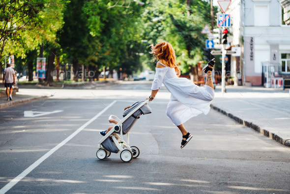 mom with a stroller crosses the road Stock Photo by simbiothy | PhotoDune