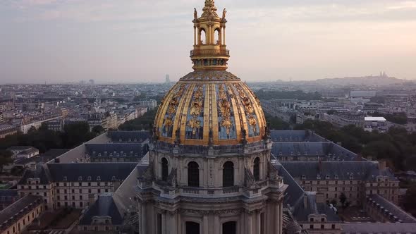 Aerialing: church with tall and gold decorated dome and wide cityscape in background, Les Invalides, alt