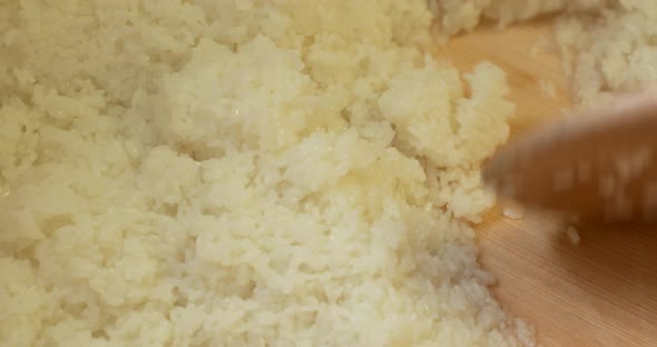 Sushi Rice Preparation - Freshly Cooked Japanese Rice Mixed By The Sushi Chef Using A Wooden Spoon. alt