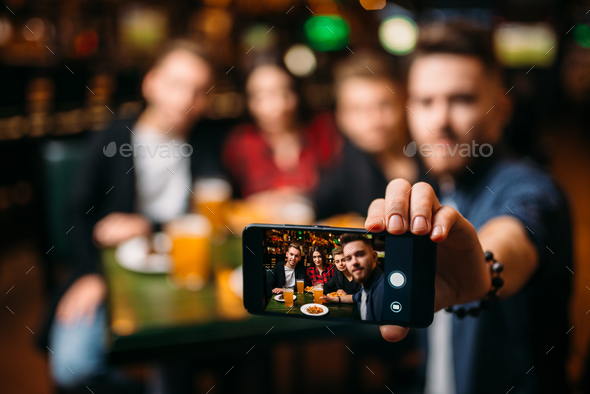 Fun friends makes selfie on phone in a sport bar - Stock Photo - Images