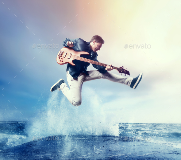 Rock guitarist with bas-guitar, snapshot in a jump - Stock Photo - Images