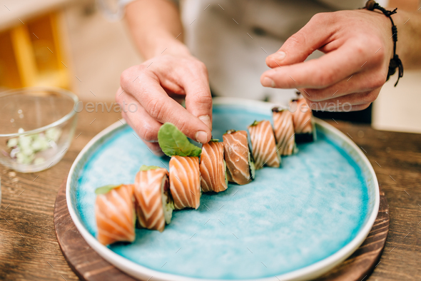 Male person cooking sushi rolls, japanese food - Stock Photo - Images