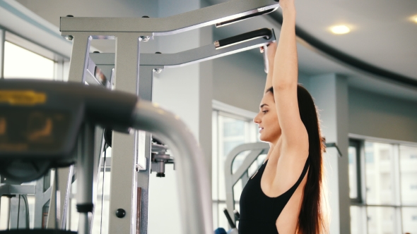 Attractive Young Woman Exercising in Gym - Training for Shoulders alt
