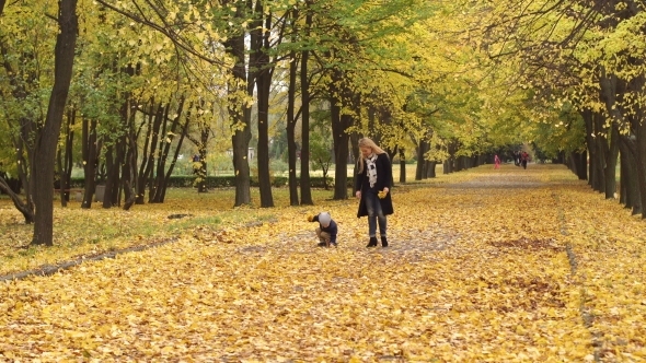 Mother and Son Walking in Autumn Park alt