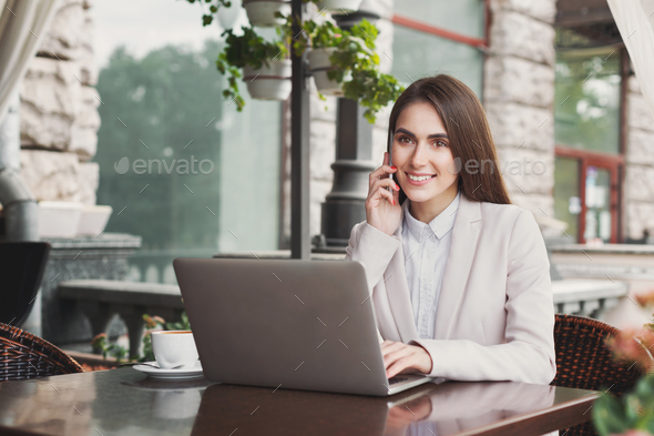 Young businesswoman looking at front, talking on phone - Stock Photo - Images