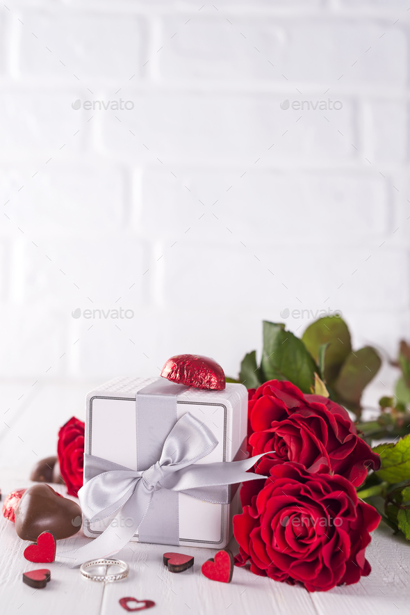 Fresh red roses and gift box on wooden table - Stock Photo - Images