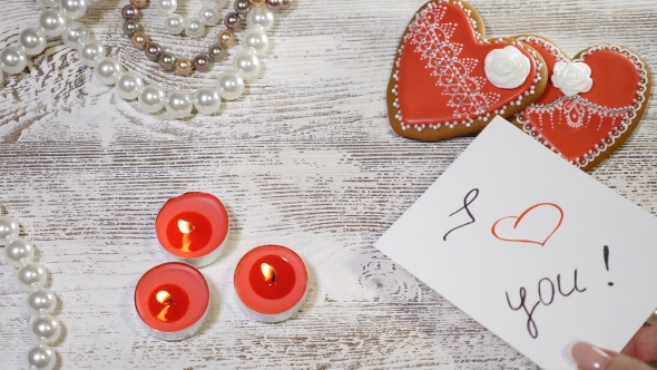 St Valentine Day Background Two Heart Shaped Ginger Biscuits, Tea Candles and Pearl Beads on alt