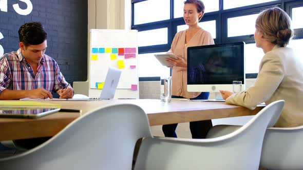 Woman interacting with colleagues in meeting alt