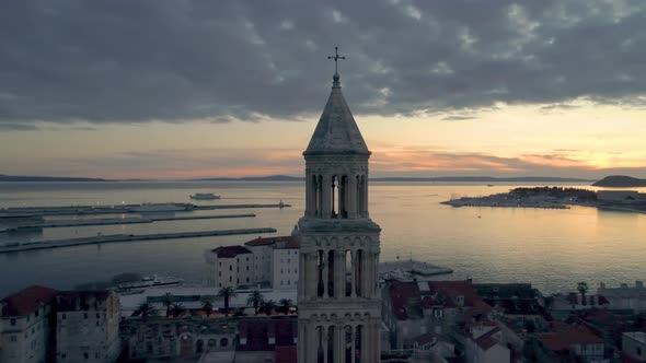 Aerial orbit view of the old town church and harbour at sunset in Split, Croatia. Beautiful sky with alt