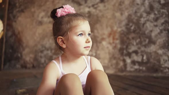 Beautiful Child Sits in an Empty Room and Smiles alt