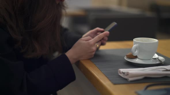 Pan Shot of Woman Drinking a Cup of Coffee Typing on the Phone