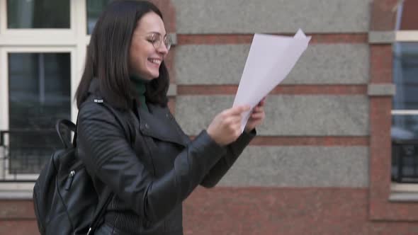 Young happy girl reads good news. alt