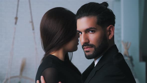 Indoor Portrait of a Sexy Bearded Seductive Darkhaired Holding in His Arms His Submissive Longhaired alt