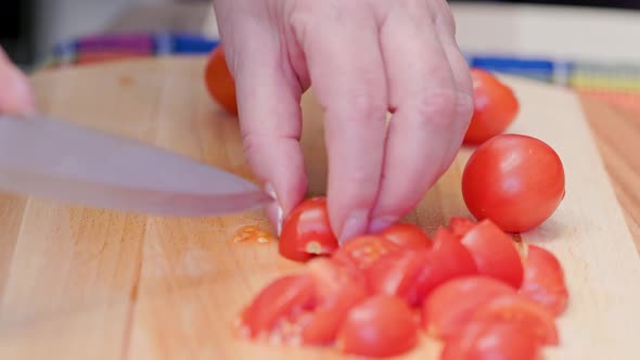 Senior Caucasian Woman Cut Red Cherry Tomatoes on Wooden Cutting Board Side View