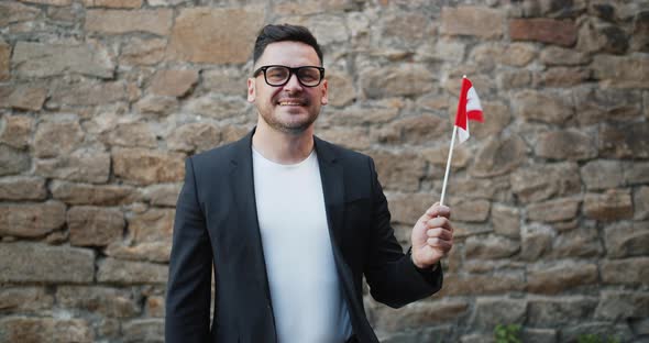 Portrait of Handsome Bearded Guy Waving Canadian Flag Standing Outdoors Alone alt