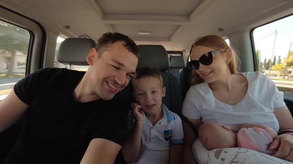 Happy Family of Four Traveling By Car alt