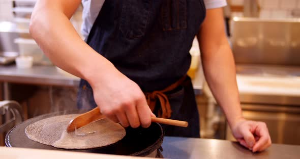 Chef preparing crepe on the pan alt