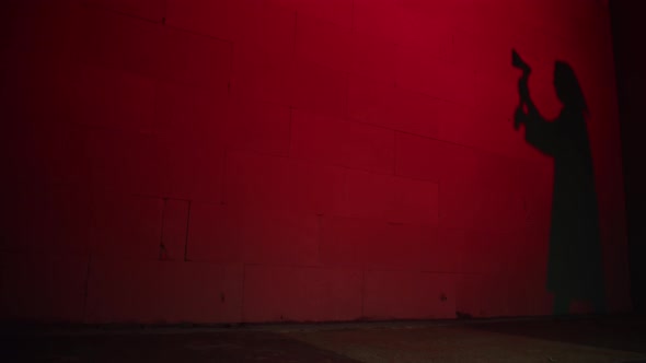 Creepy Death Silhouette Walking with Axe on Red Background alt