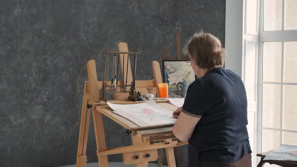 Senior Female Finishing Painting in Art Studio alt