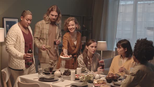 Friends Clinking Glasses after Setting up Table alt