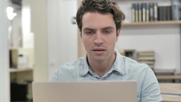 Shocked Creative Man Wondering and Working on Laptop alt
